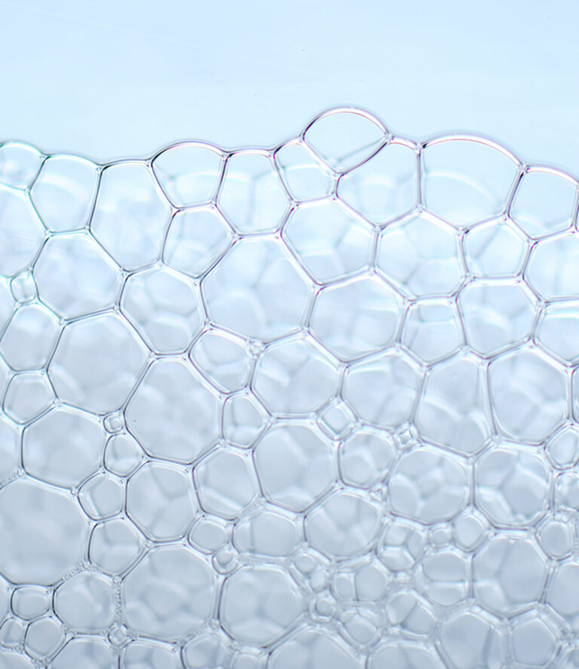 Struktura przezroczystych bąbelków na jasnym tle.